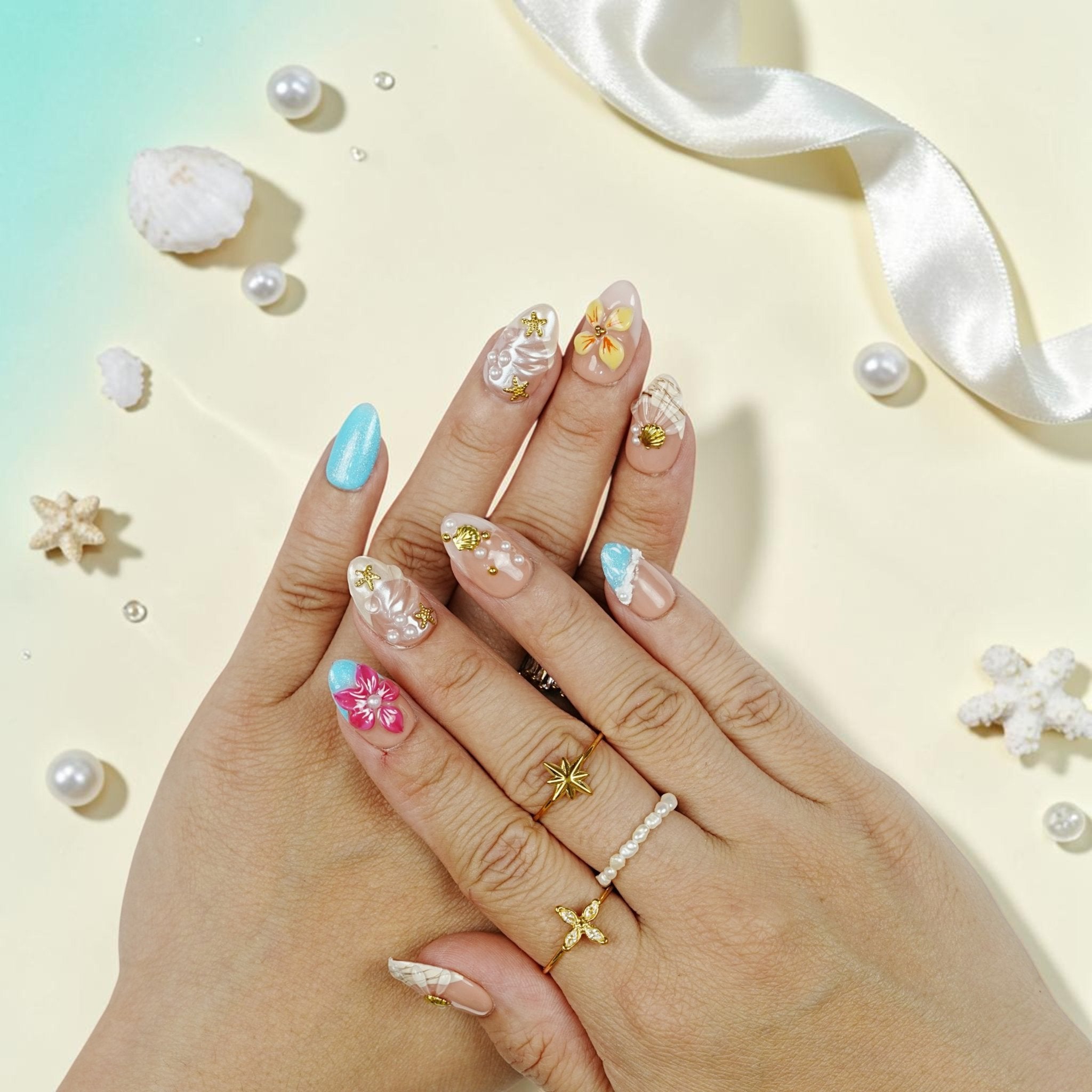DSC00060 hand wearing tropical press on nails with a 3D yellow tropical flower, gold shell and pearls