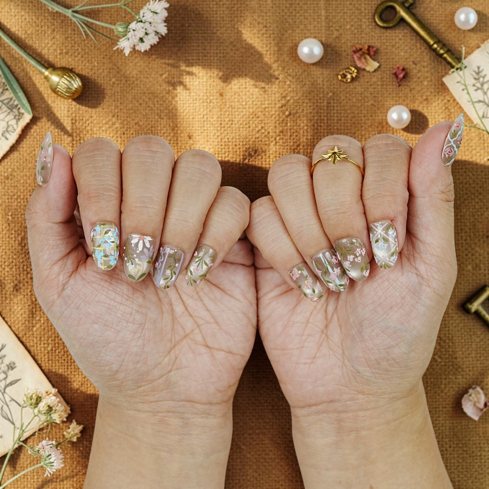 DSC00081 two hands showing hand painted wildflower press on nails in soft pastels
