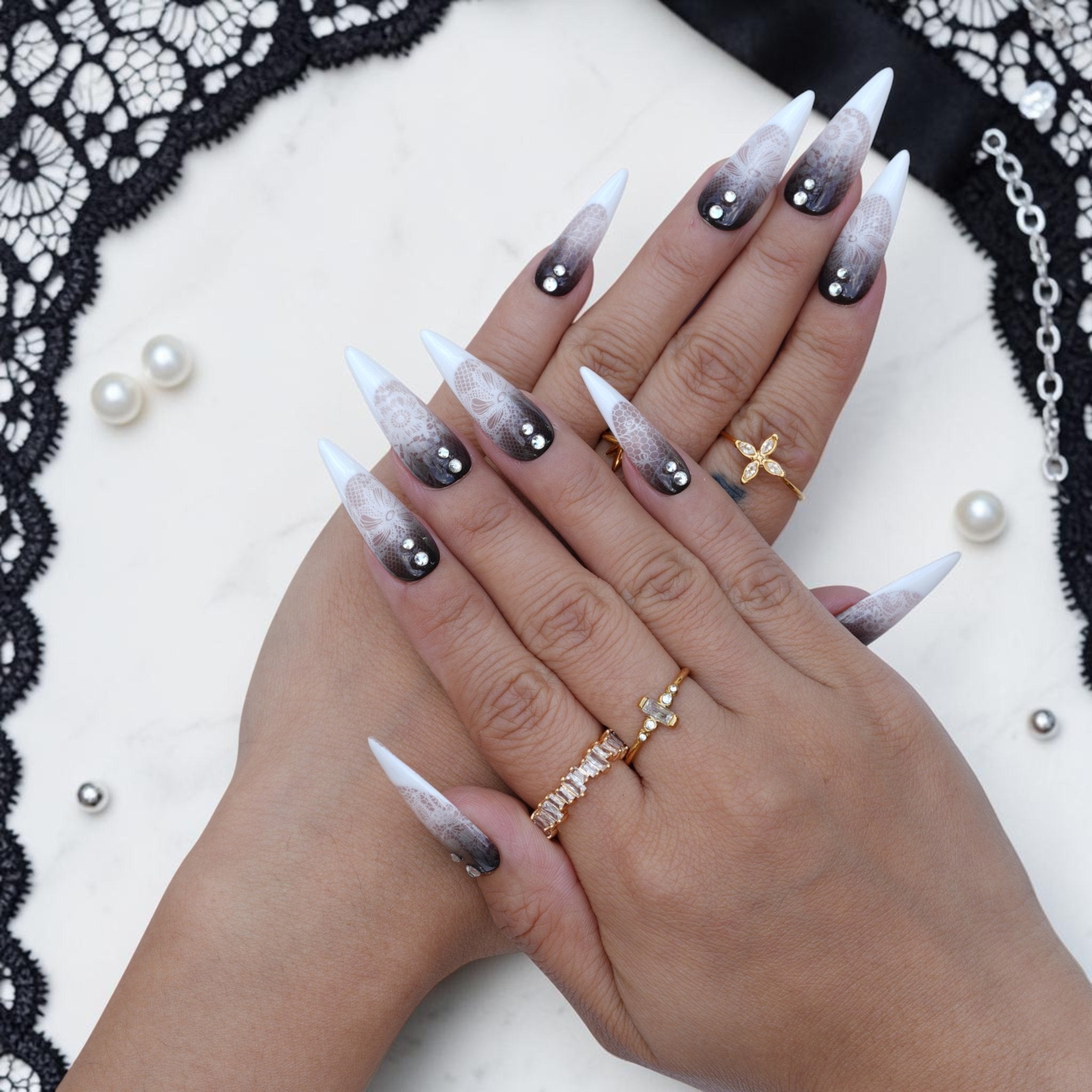 Black lace press on nails close up with floral lace pattern and crystal accents
