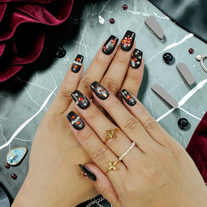 DSC00084 hand wearing gothic black press on nails with red heart gems and studs