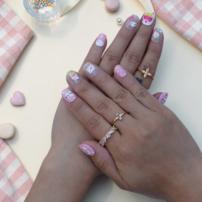 Cute cat press on nails worn on hand in pink with kittens, cupcakes and polka dots