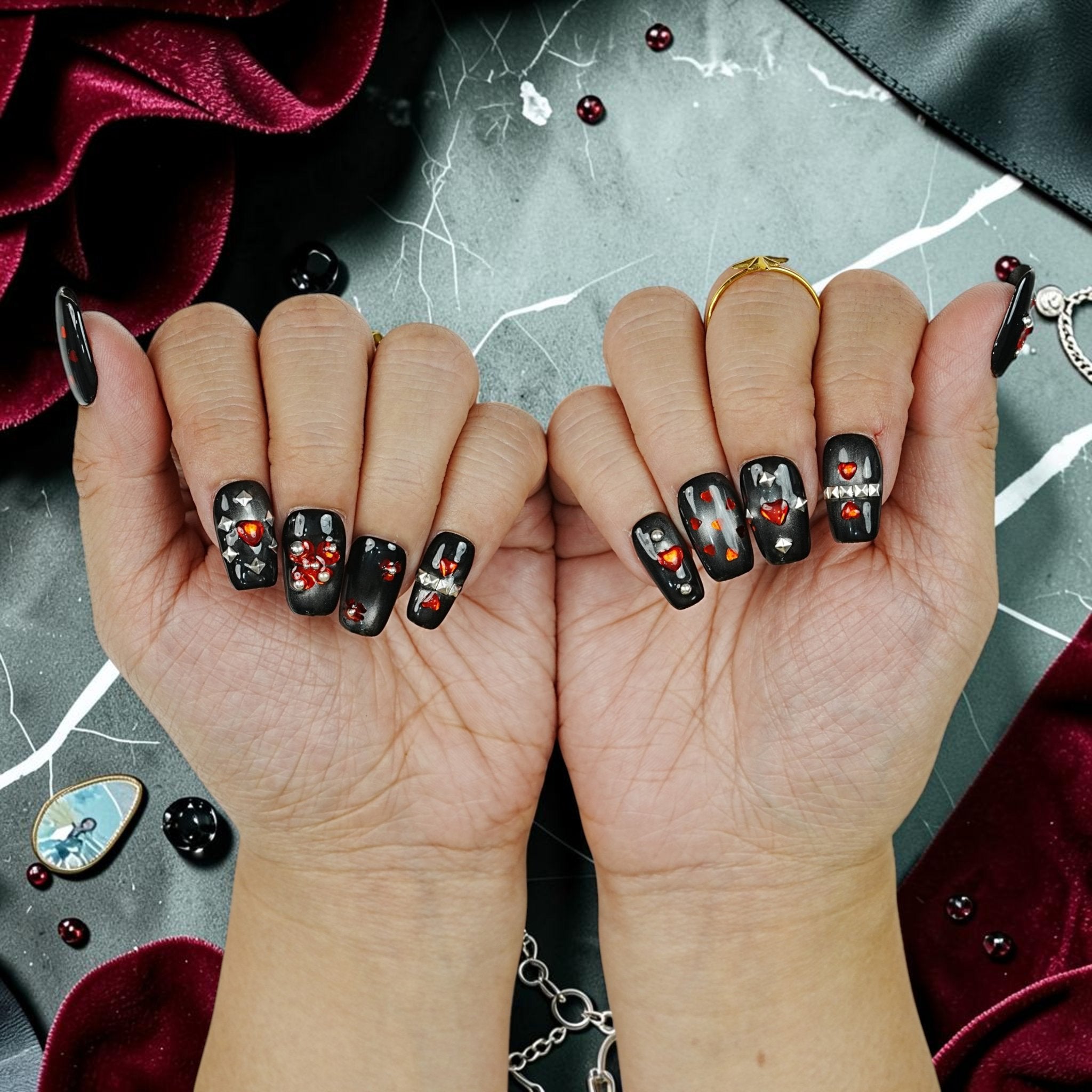 DSC00090 two hands showing gothic press on nails in black with red hearts and silver studs