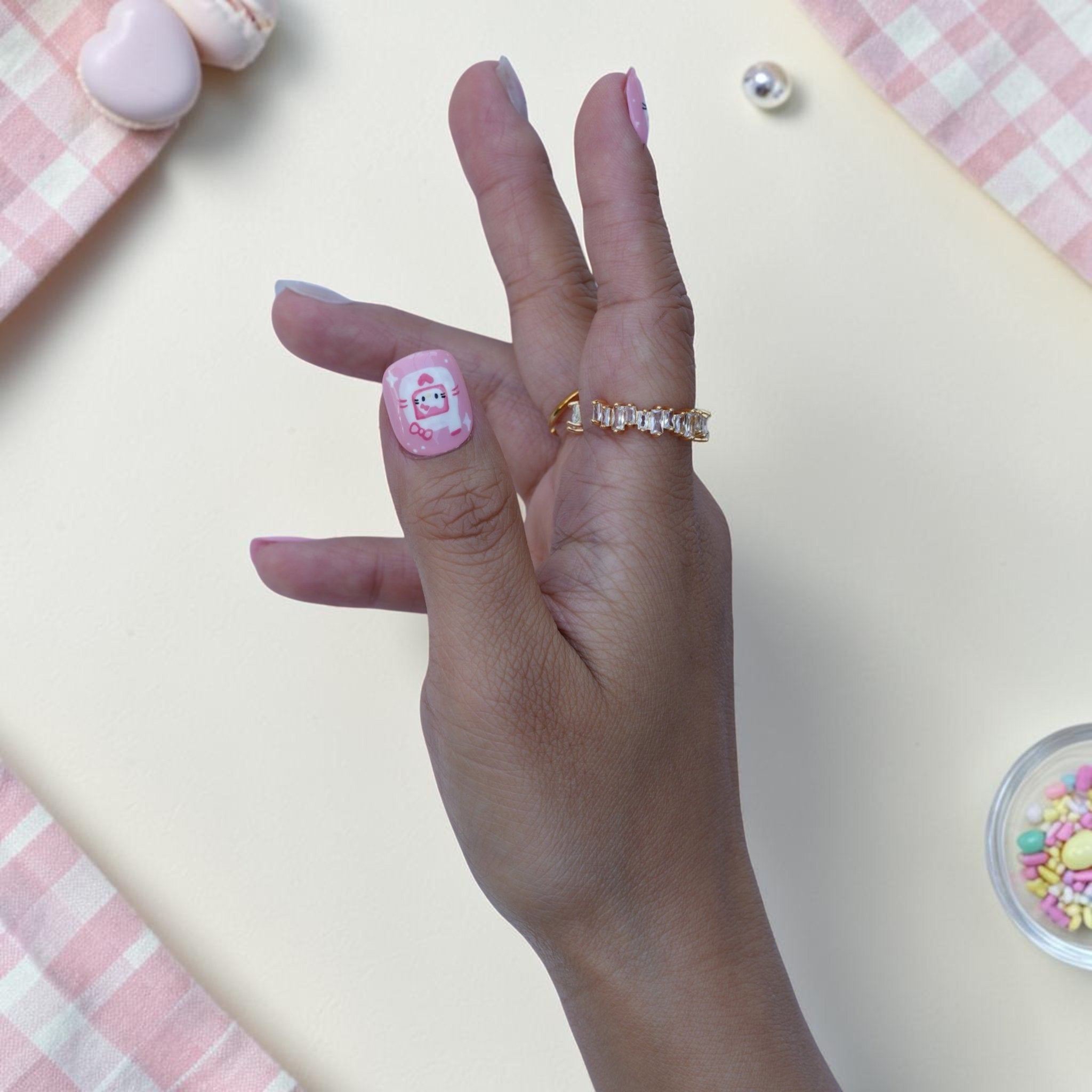 Sugar Kitten press on nails on hand with cartoon kitten and pink bow