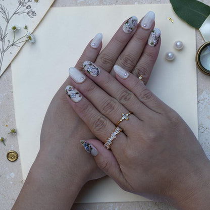 Vintage bird press on nails worn on hand with painted songbirds, blossoms and gold rings