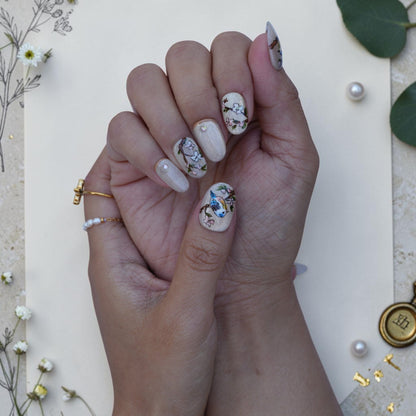 Vintage botanical press on nails with painted birds and blossom on a shimmer base