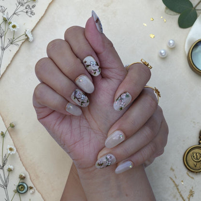 Bird press on nails shown on both hands with vintage songbirds and blossoms