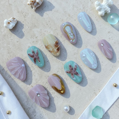 Handmade ocean press on nails flat lay in mint, pearl and gold with 3D shells, starfish and pearls