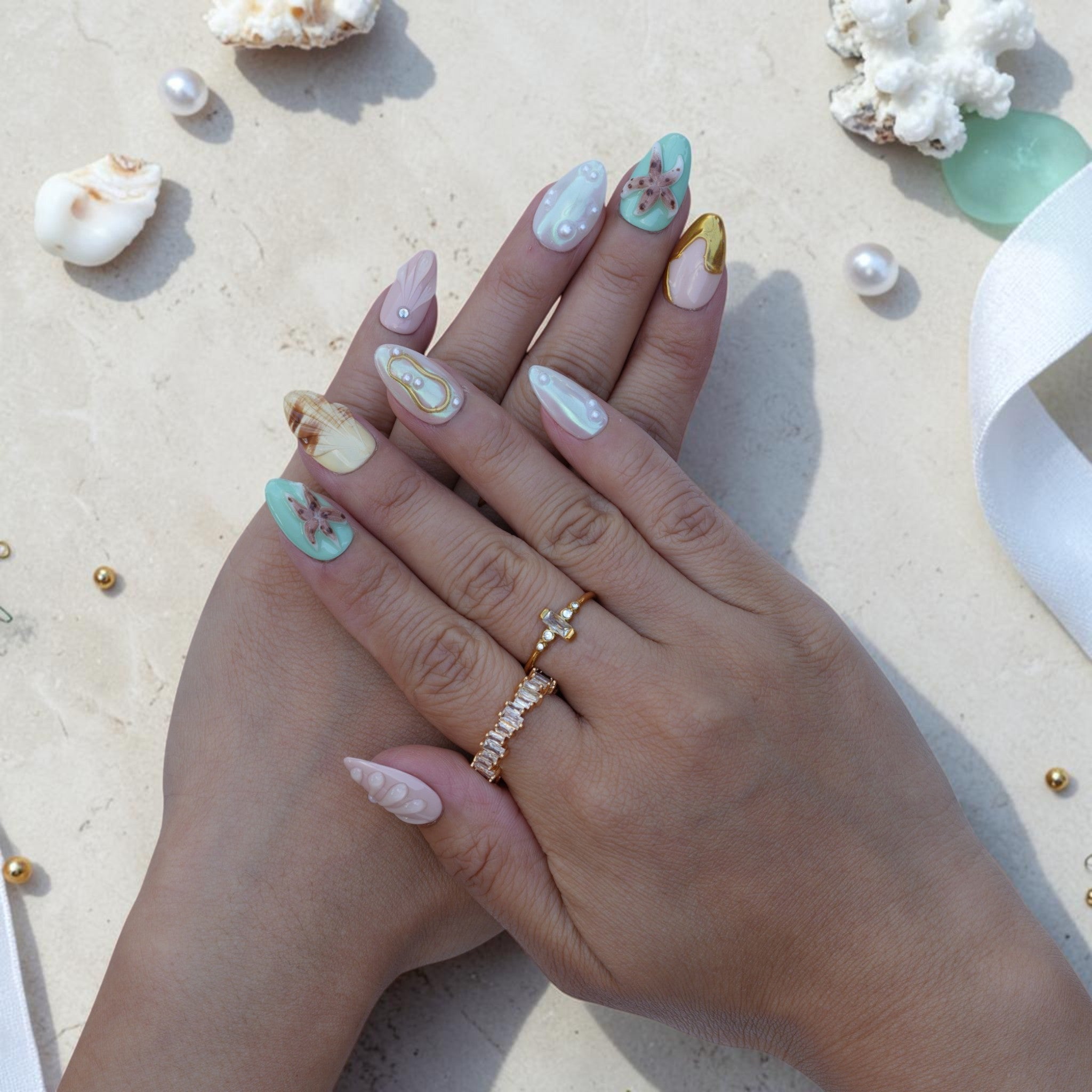 Pastel ocean press on nails worn on hand with mint starfish, gold accents and pearls