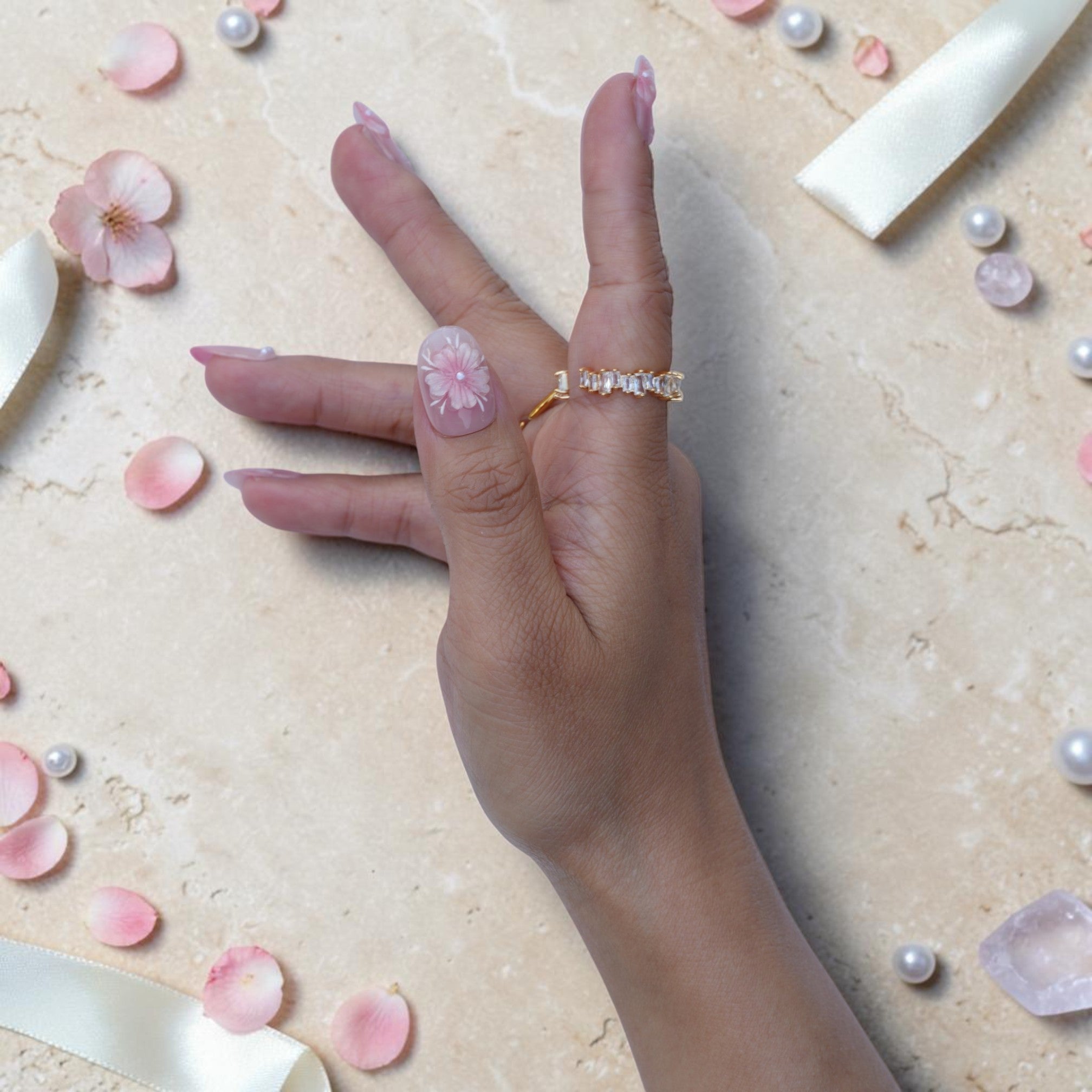 Soft pink blossom press on nails close up with a pearl centred flower on an oval nail