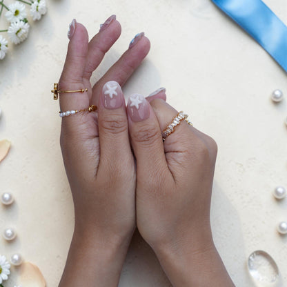 Both hands wearing Pearl Lagoon mermaid press on nails with shells and flowers