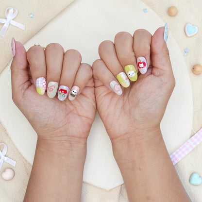 Both hands wearing kawaii cat press on nails in pastel pink, mint and yellow