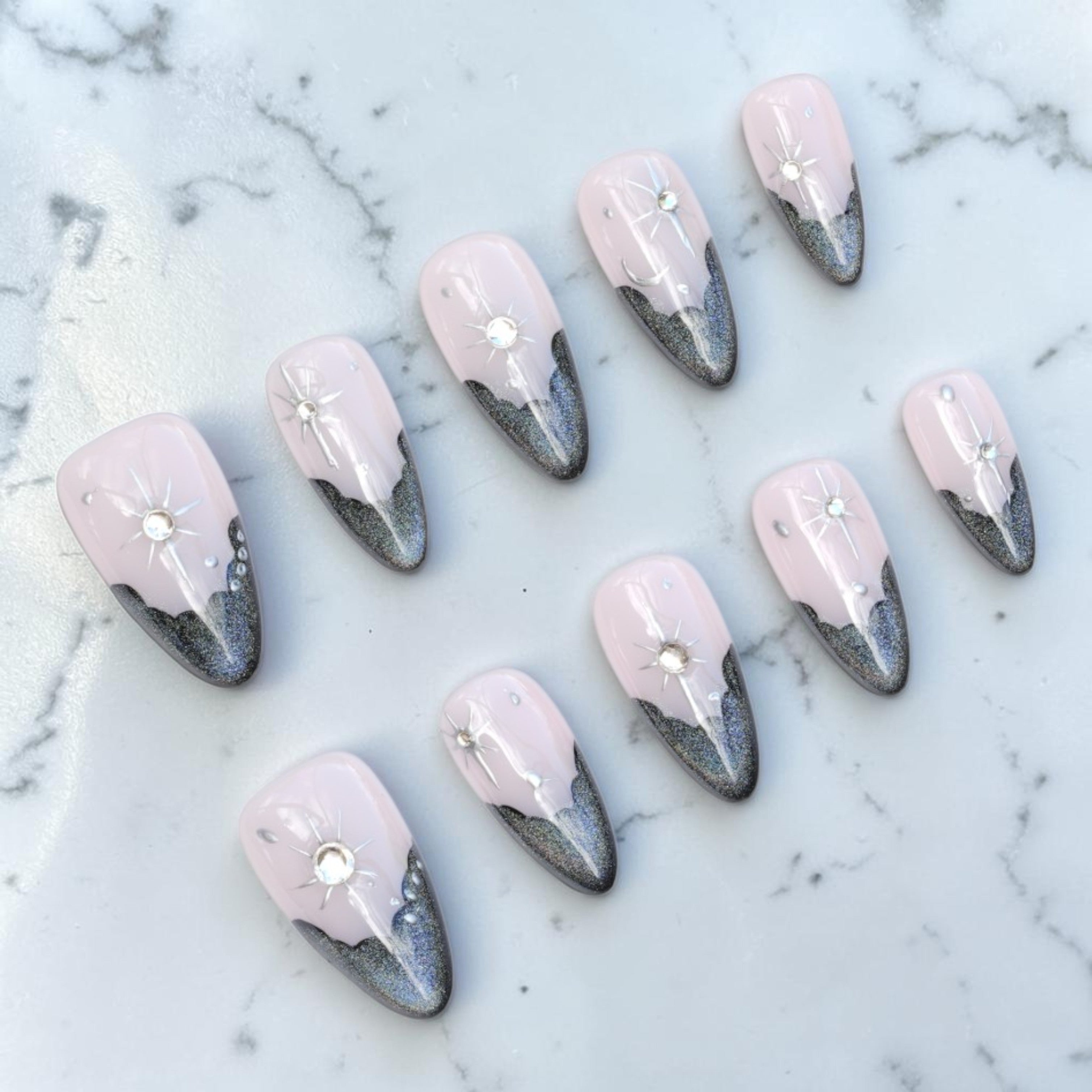 Black french tip press on nails with cat eye shimmer and celestial star on marble