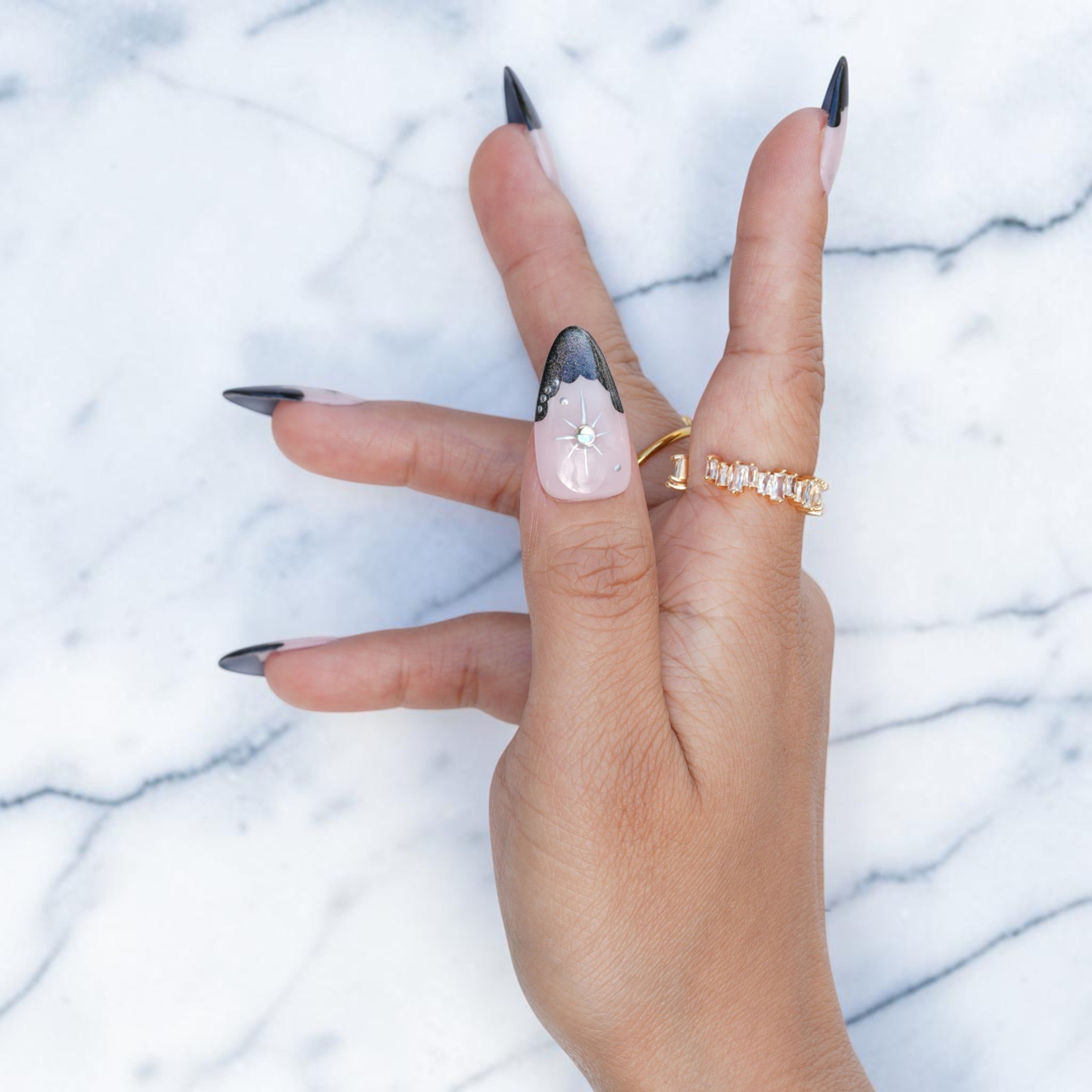 Close up of a cat eye French tip with a silver star and rhinestone