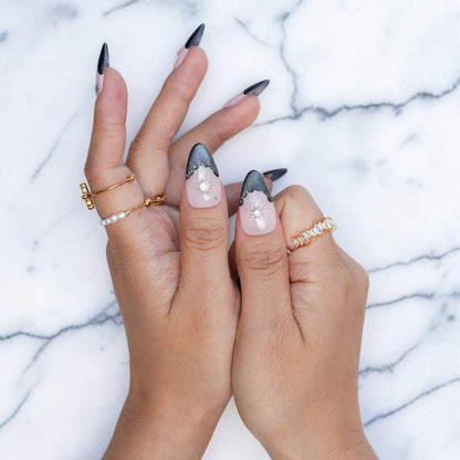 Midnight nude almond nails with dark French tips and celestial stars