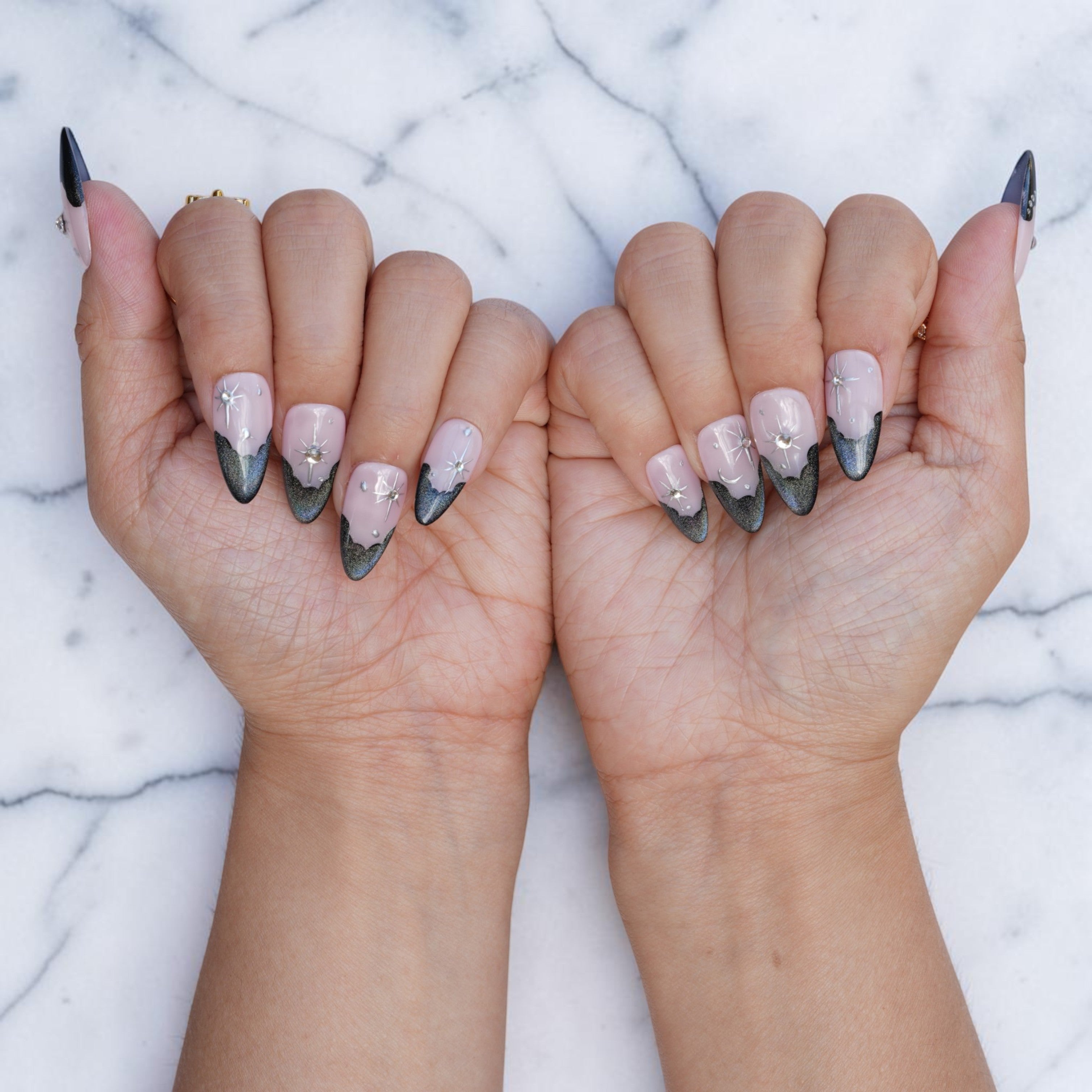 Both hands wearing Midnight Wish cat eye french tip press on nails with star and gem