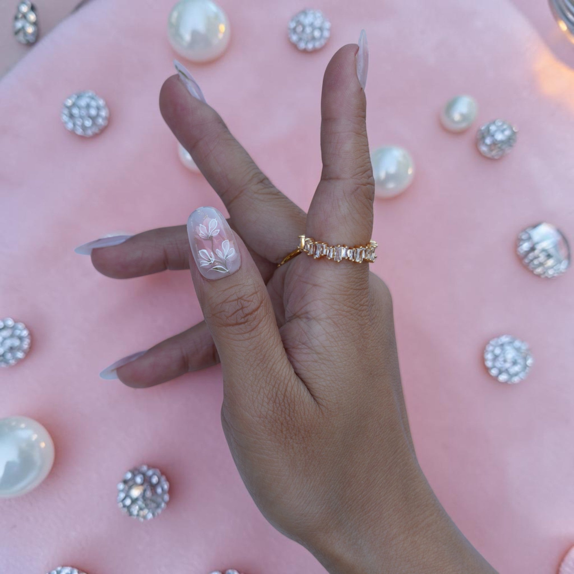 Single hand showing minimalist white floral nude press on nails