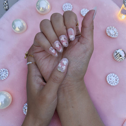 Close up of white magnolia line art on a sheer nude press on nail