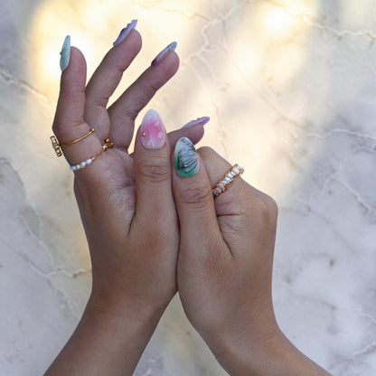 Close up of a pink iridescent nail with 3D water droplets