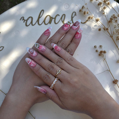 Hand painted rose press on nails in soft pink on a long almond shape