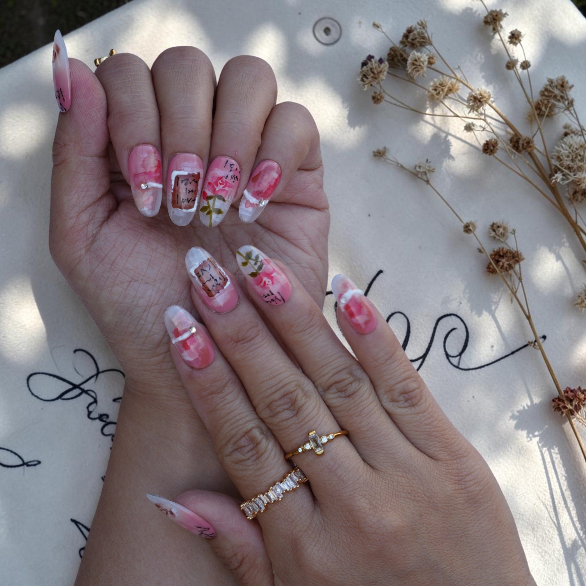 Long almond press on nails with pink roses and handwritten script