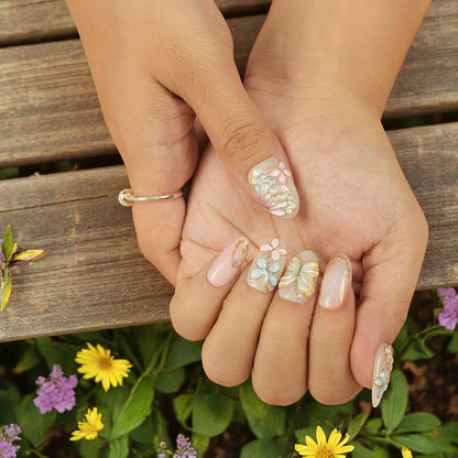 Closeup of butterfly press on nails against wildflowers – stick on nails with 3D design
