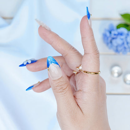 Side angle of Blue Mirage press on nails highlighting shimmer finish and curved long almond shape.