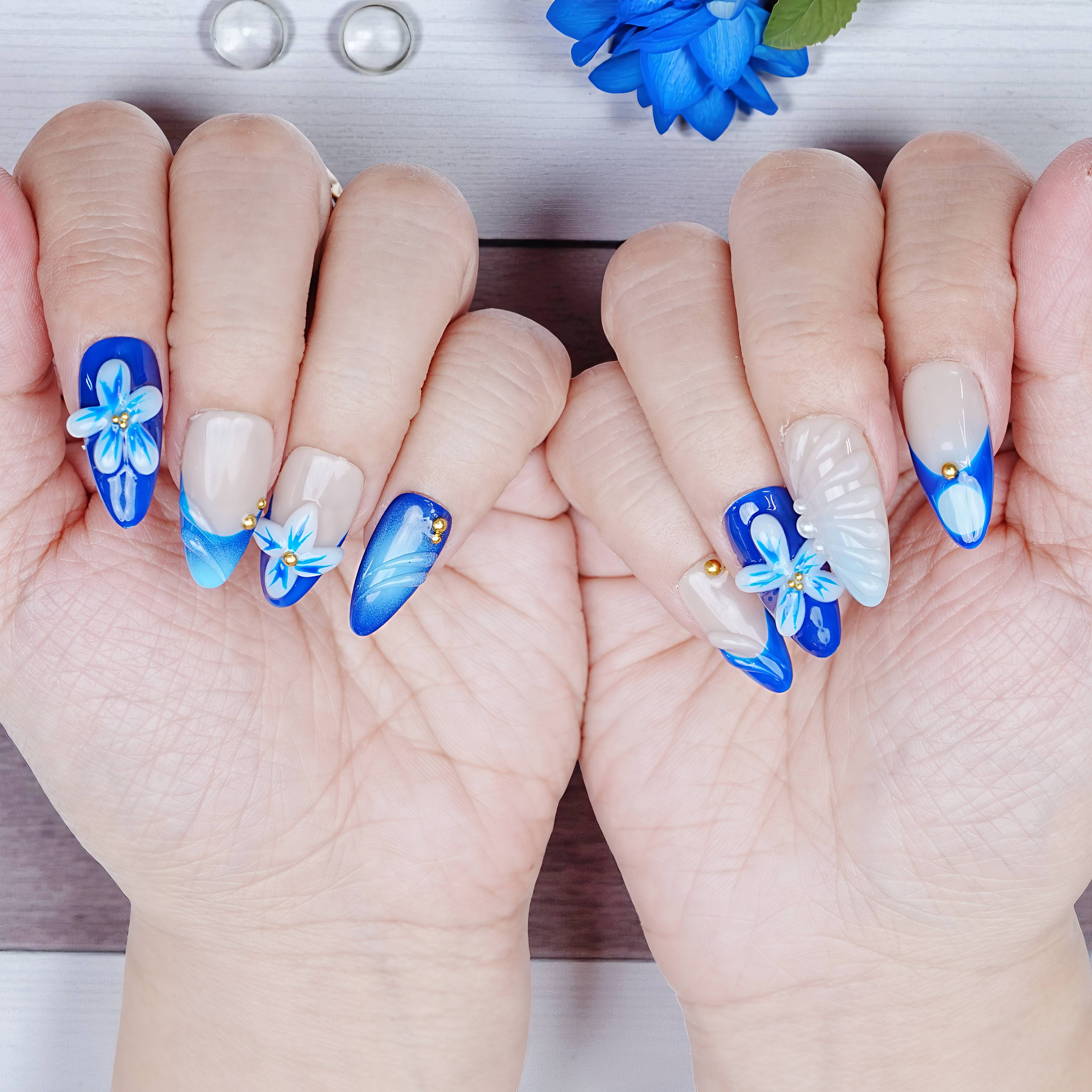 Both hands with full Blue Mirage set, showcasing alternating blue florals and pearl shimmer nail art.