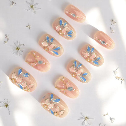 Full set of press on nails with pastel nude base and blue floral patterns, perfect for everyday wear or special occasions