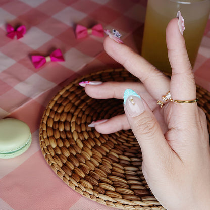 Side angle showing sculpted nails with heart dot design and pearlescent pastel finish.