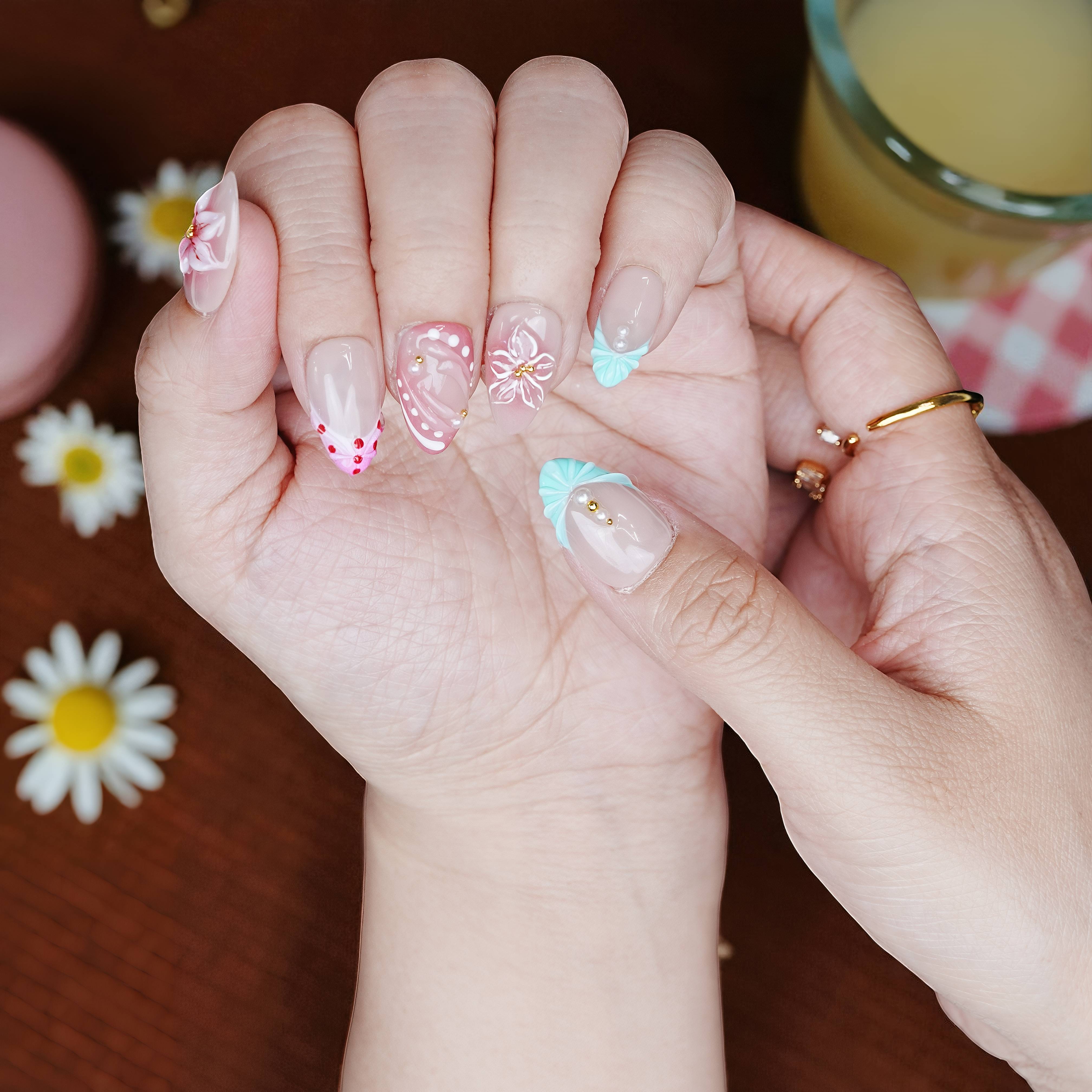 Nail set shown with alternate mint accent nail and layered flower designs for added visual interest.