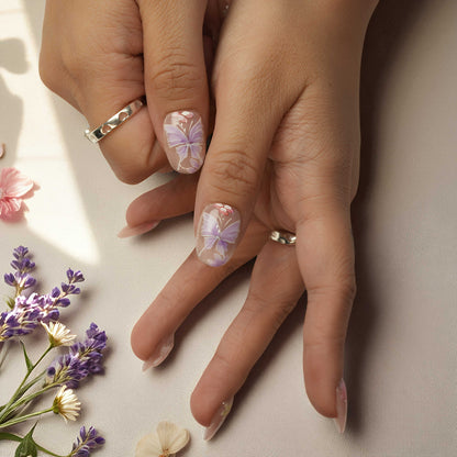 Artistic press on nail set featuring pearl accents, sculpted petals, and soft glitter tips