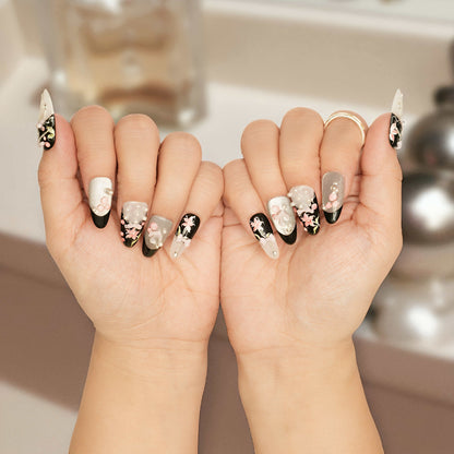 Close-up of Midnight Lily Bloom press on nail featuring black and pearl white base with sculpted pink lily and pearl accents.
