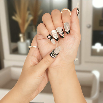 Black press on nails with pearl white accents and sculpted 3D pink lilies and glossy finish.