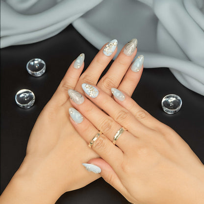 Glossy nude nails with white pearls and sculpted 3D heart centerpiece