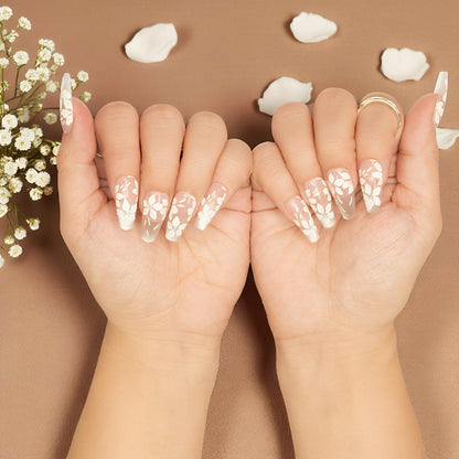 Coffin nails with soft pink hue and intricate white floral details, glue on nail set