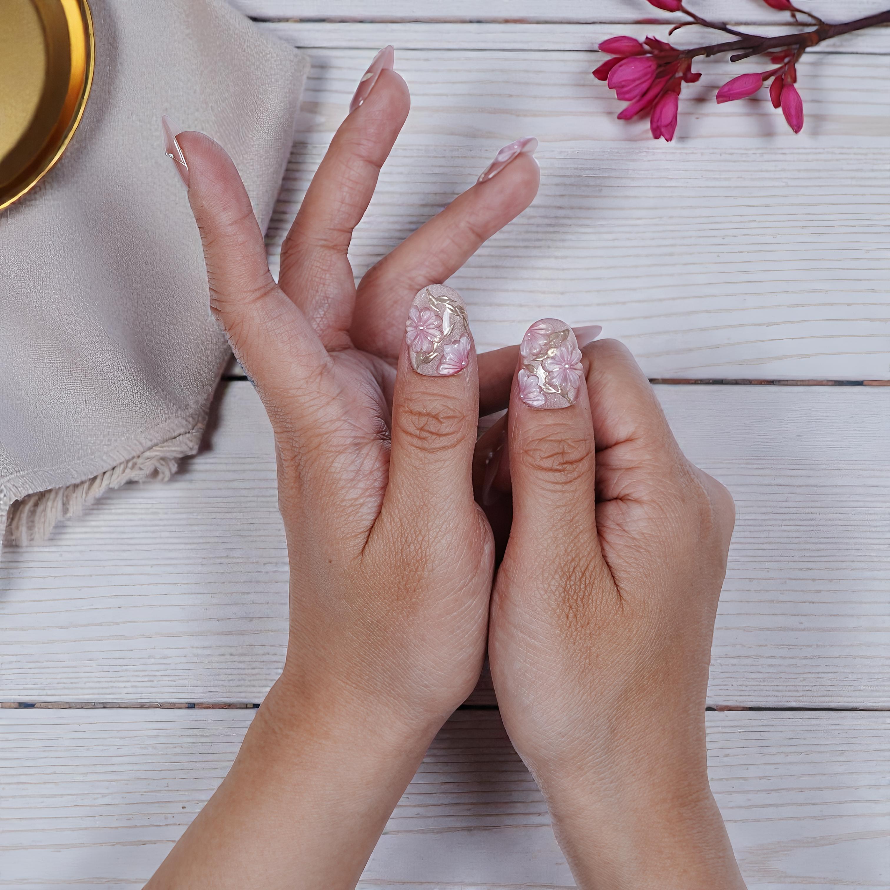 Side angle of Sakura Glint nails showcasing sculpted floral and rhinestone art