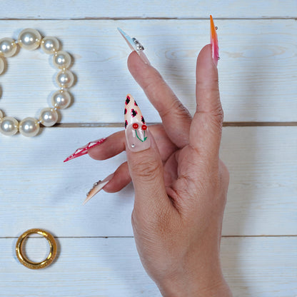 Close-up of nail with red-yellow ombre and chrome tip on stiletto shape