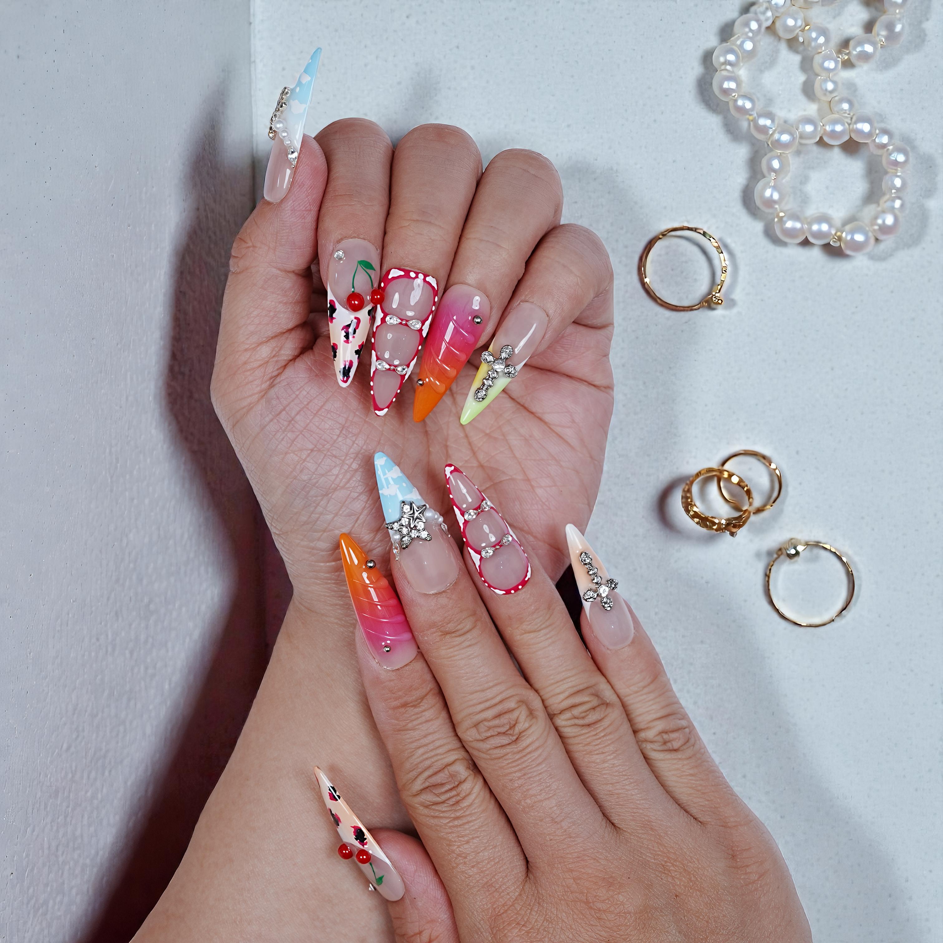 Both hands showing stiletto press on nails with rhinestone