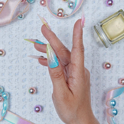 Side view of left hand showing pink and blue pastel gradient with 3D white bow and tiny star gem details