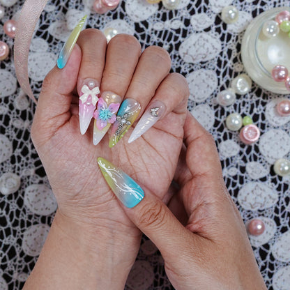 Right hand displaying pearly accents and translucent base with floral and cross designs in Aurora Belle Garden