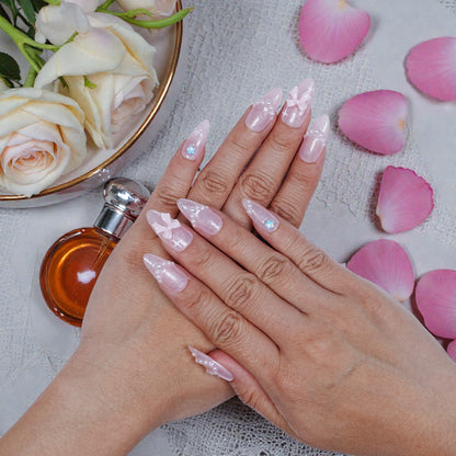 Hand model wearing blush artificial nails with petals and fragrance props