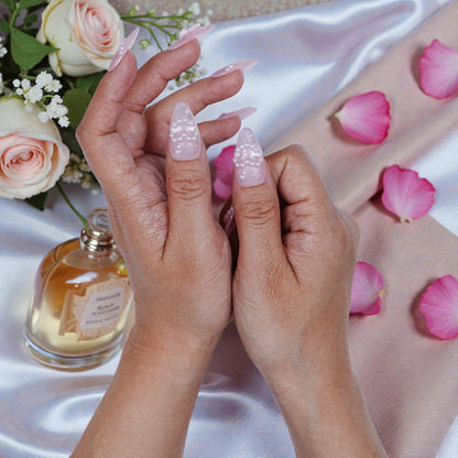 Artificial nails held in hands with silk background and romantic setup