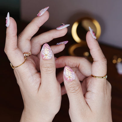 Curled fingers pose featuring high-gloss chrome pink nails with layered sculptural bow designs