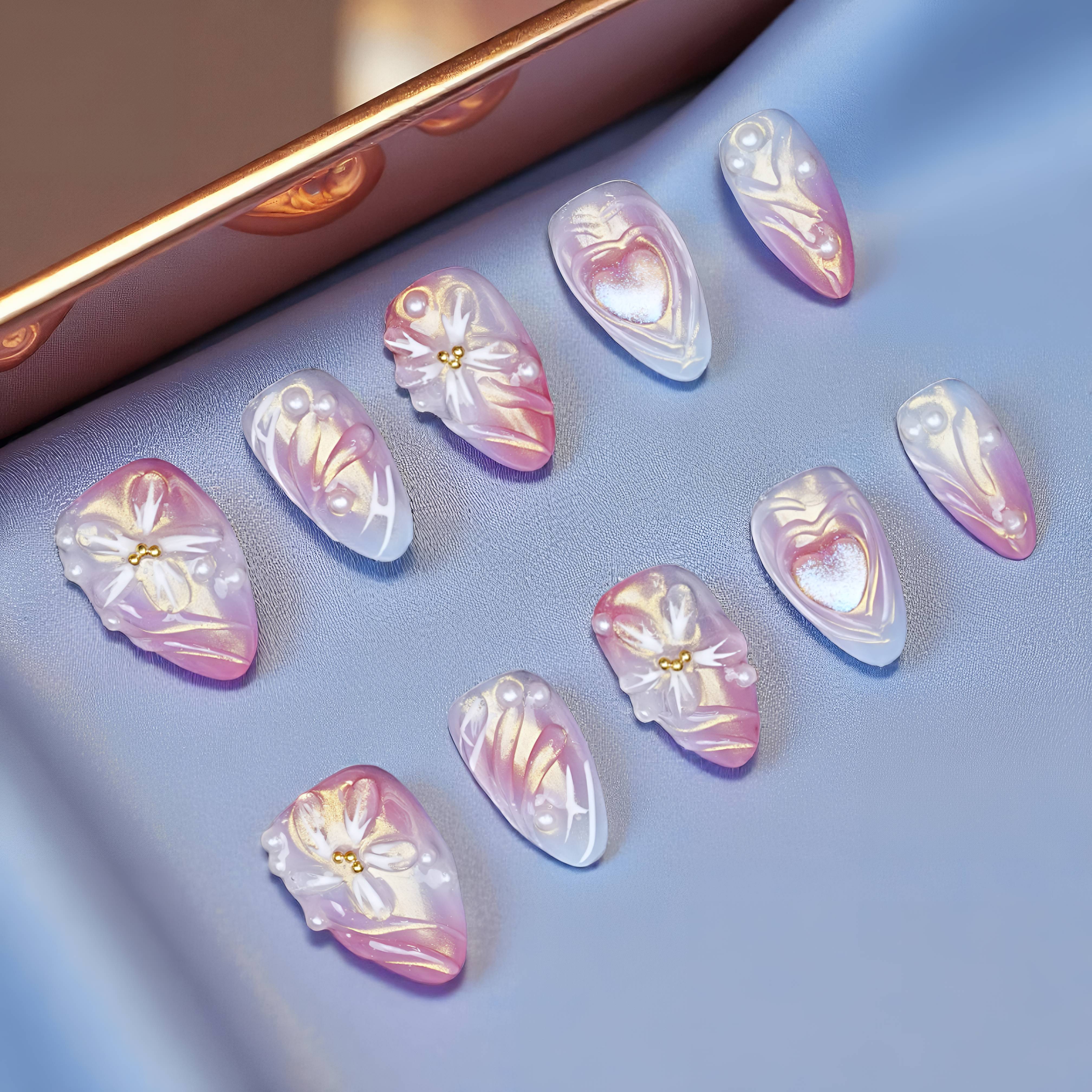 Flat lay of Twilight Bloom press on nails arranged in rows, featuring gradient chrome base, sculpted bows, and lilac tips on a jewelry tray.
