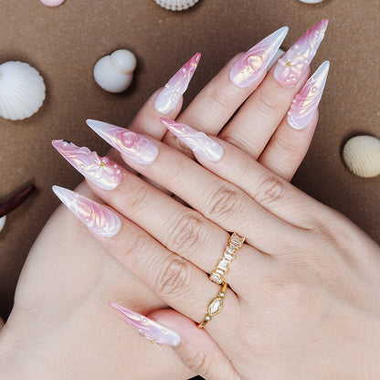 Hand pose showing glossy stiletto press on nails with pink and white chrome finish, 3D bows, hearts, and pearls