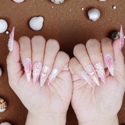 Both hands showcasing pearl pink press on nails with sculpted heart, bow, and swirl effects

c502