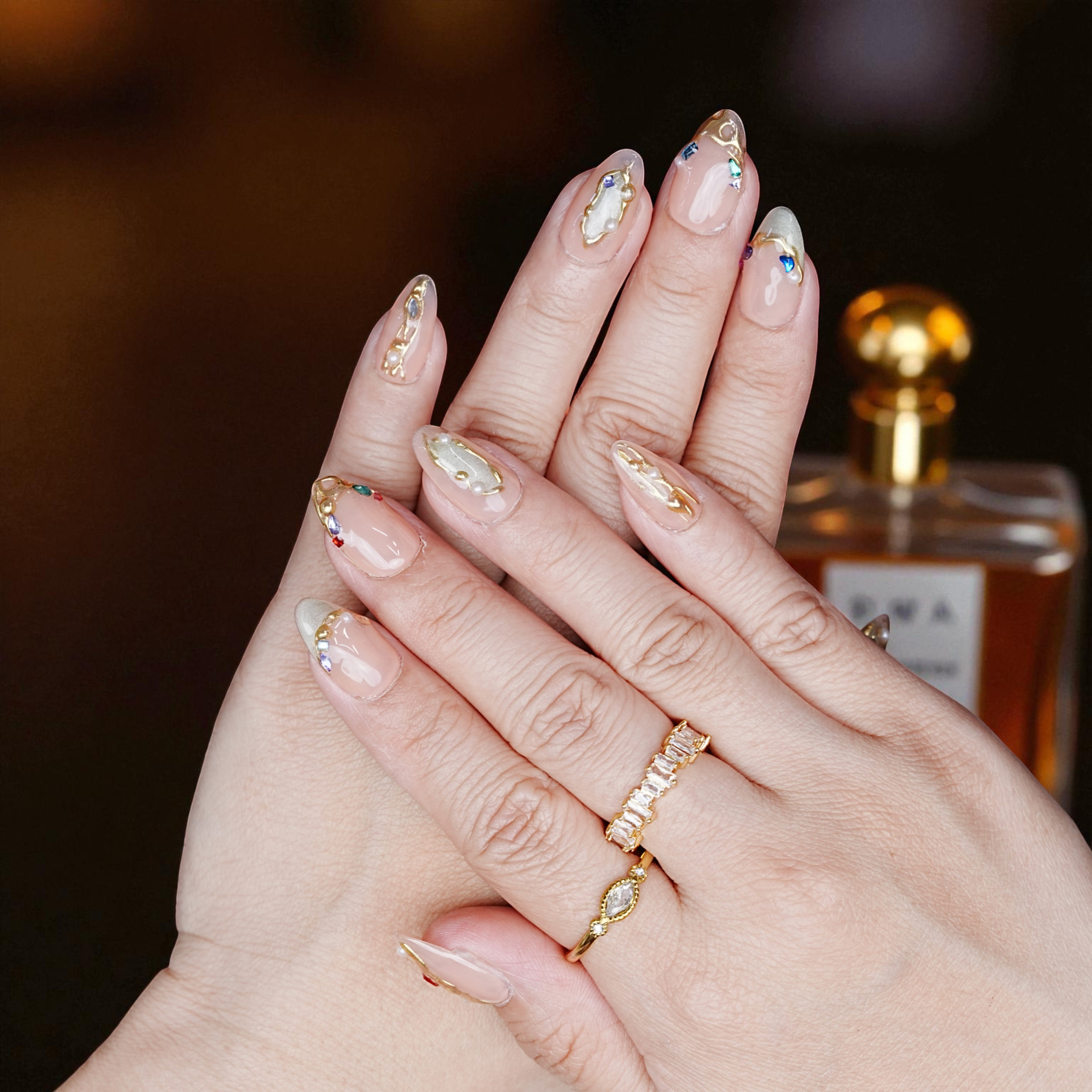 Hand wearing blush chrome petal nails with elegant pink shimmer finish