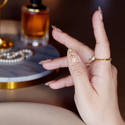 Close-up of blush chrome floral press on nails with almond shape