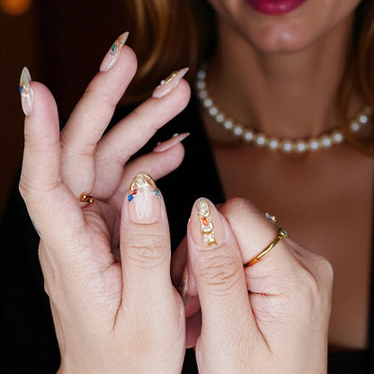 Glossy blush pink chrome nails shown on hand with pearl accents