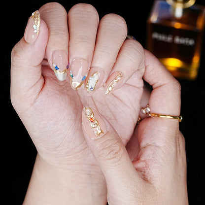 Long blush chrome nails with floral pattern held in graceful pose
